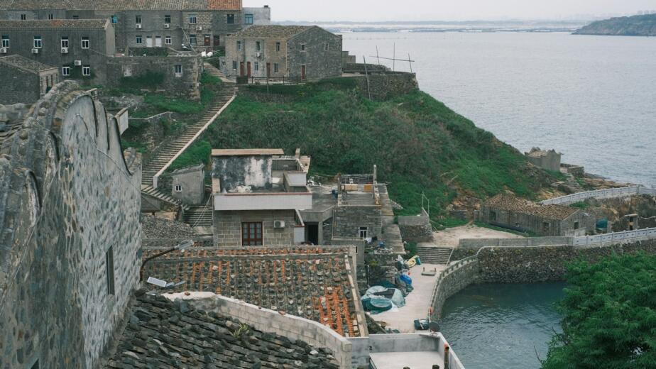 Stone buildings on a coastal hillside overlooking the sea.