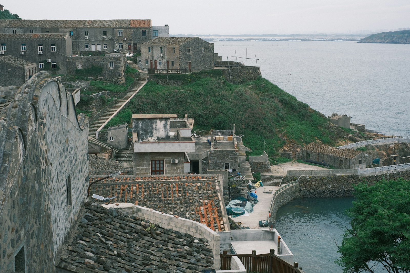 Stone buildings on a coastal hillside overlooking the sea.