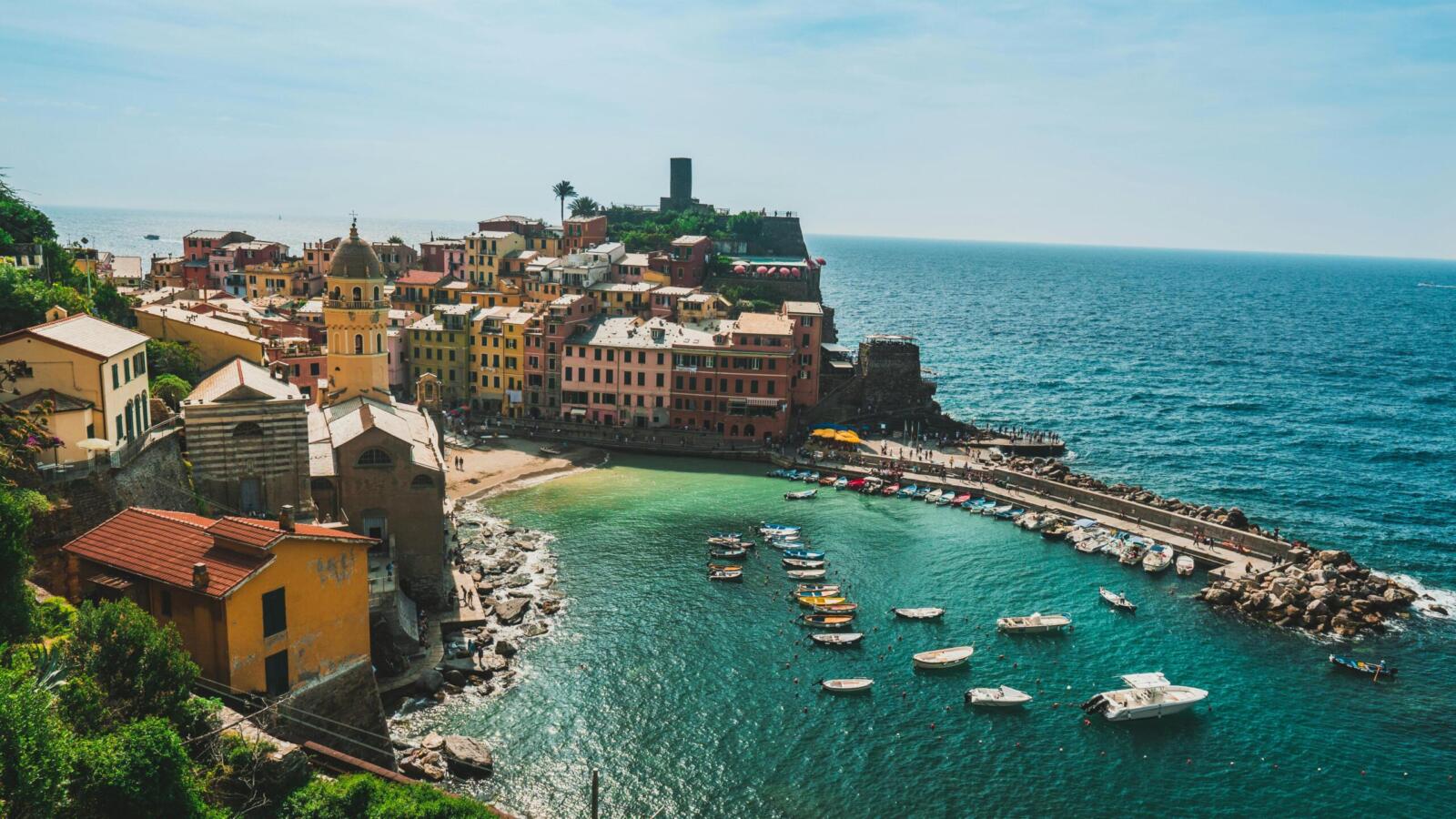 A picturesque aerial view of Vernazza's colorful buildings and harbor along the Italian coastline.