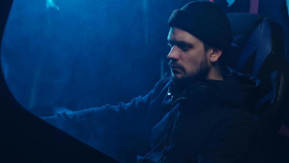 A contemplative scene featuring a man with headphones immersed in a moody blue ambiance.