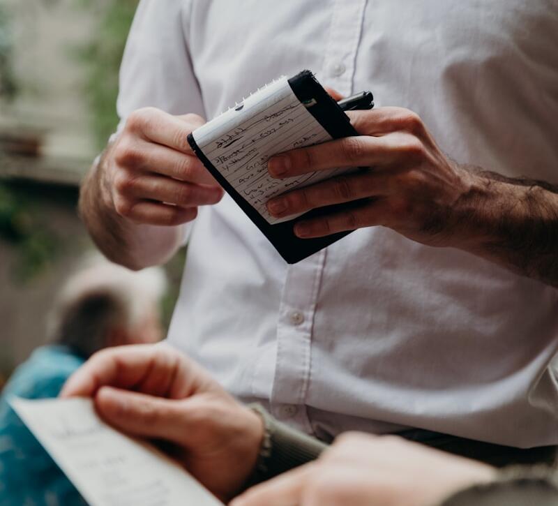 man in white button up shirt holding black and white box
