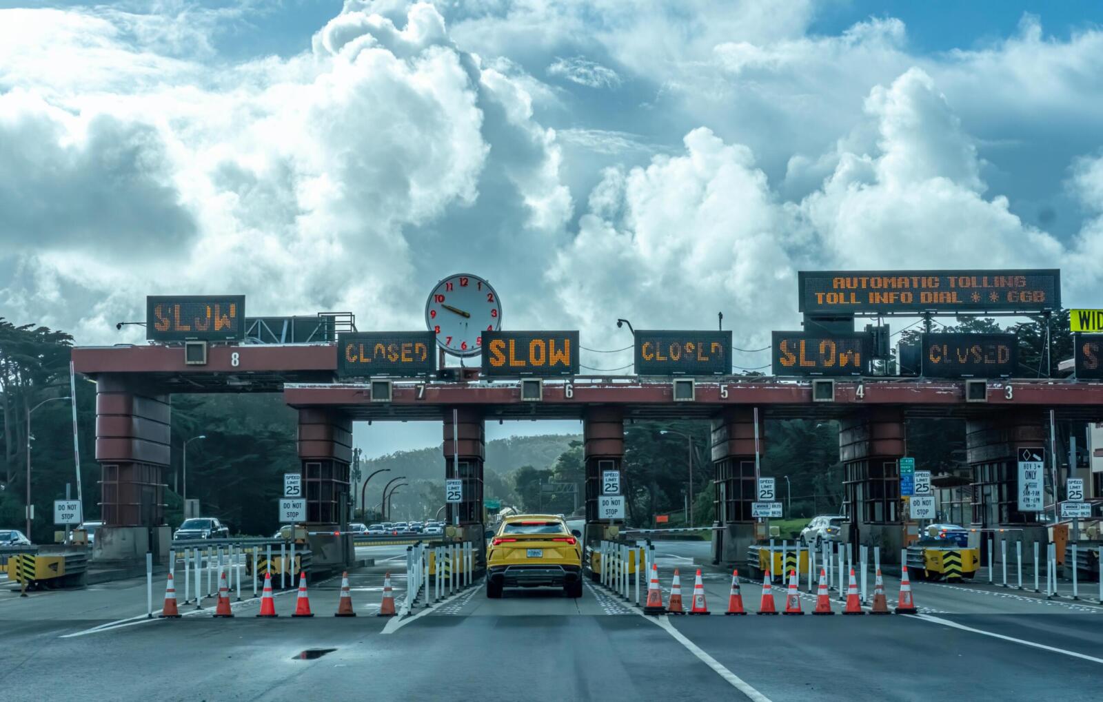 View of vehicles approaching the toll plaza at Golden Gate Bridge in San Francisco under a cloudy sky.