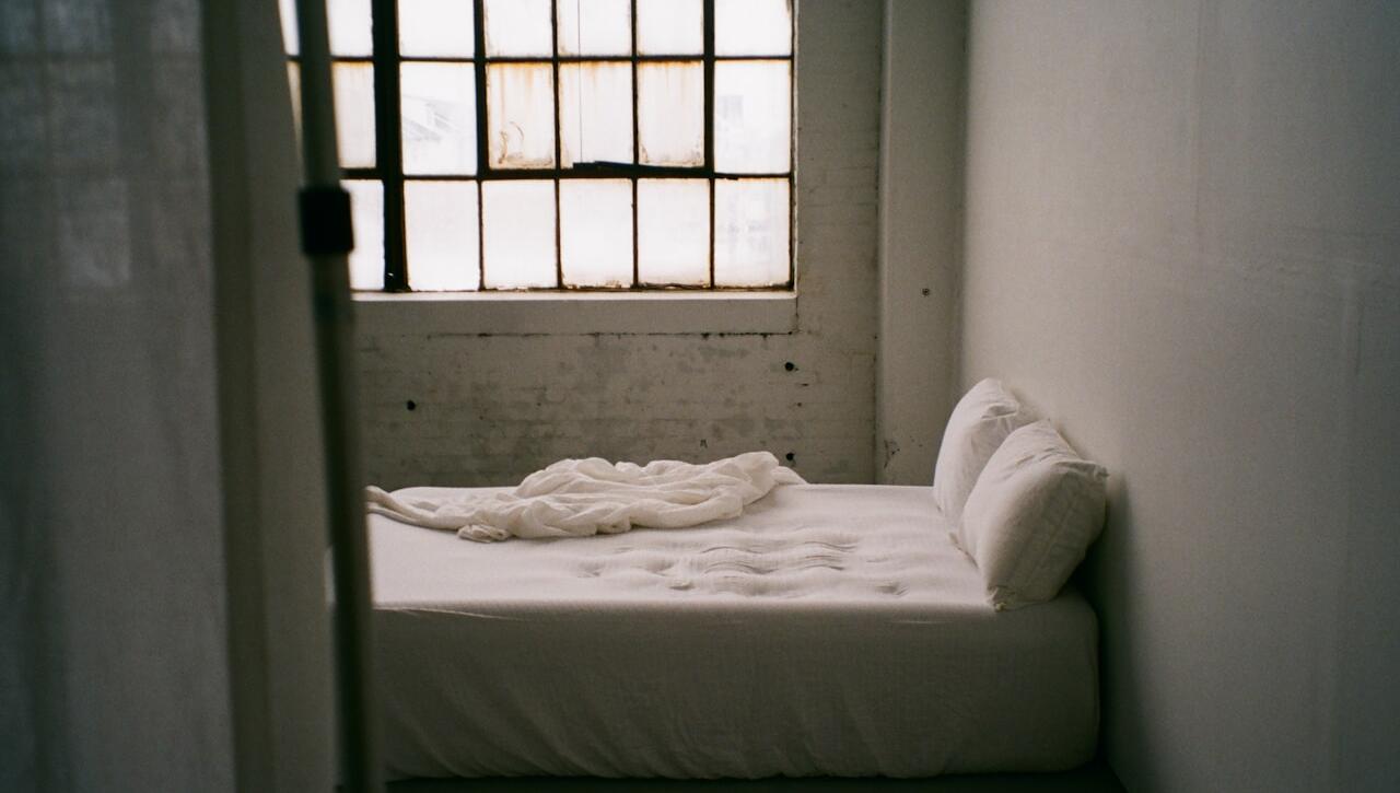 a small bed in a small room with a window