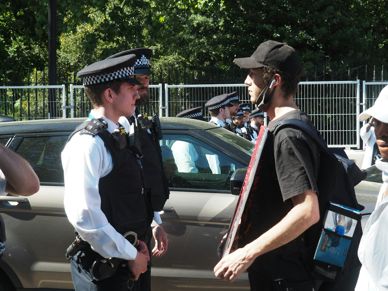 man in black vest and white dress shirt standing beside car during daytime
