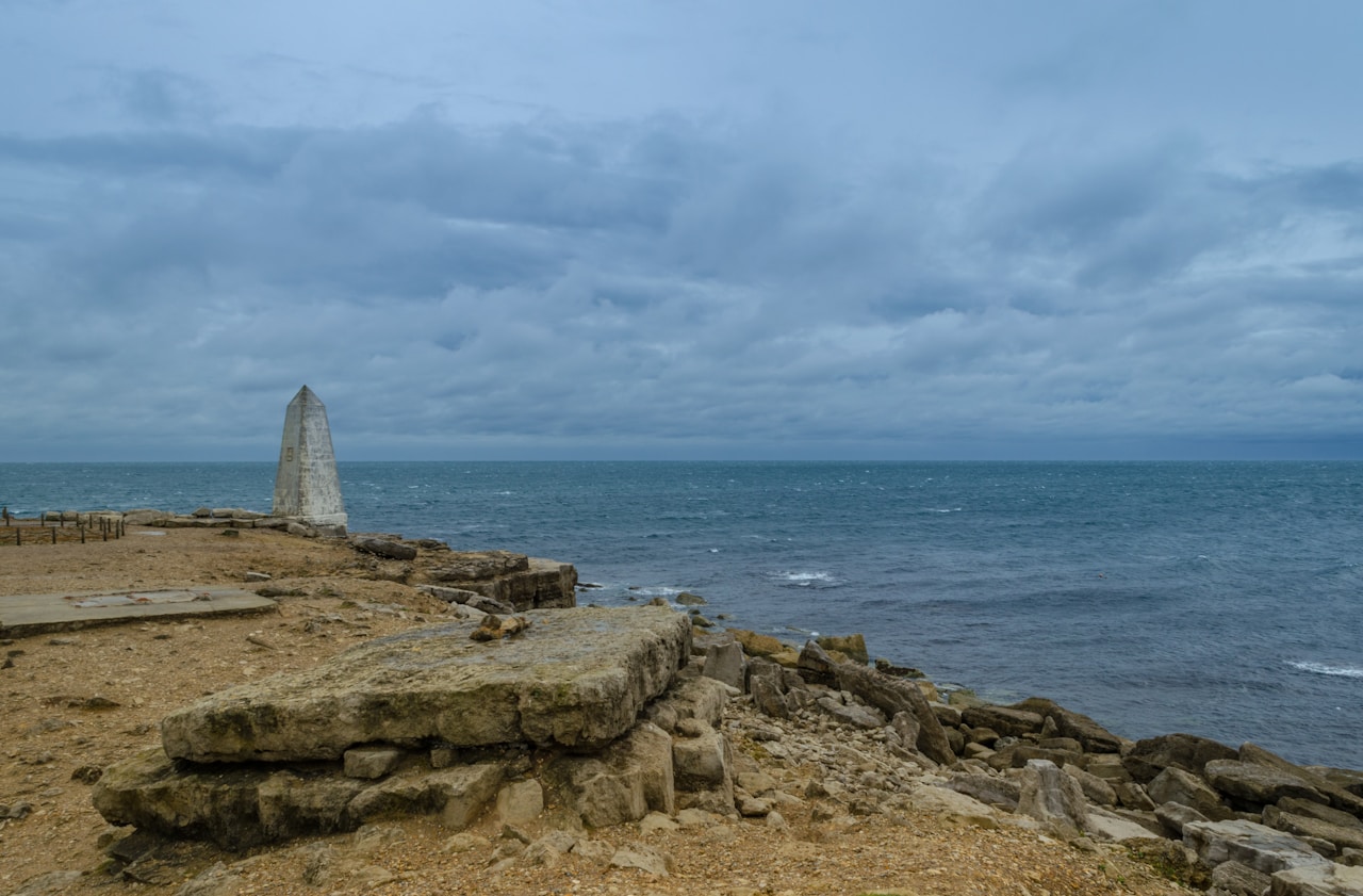 a rocky beach with a large rock structure in the distance