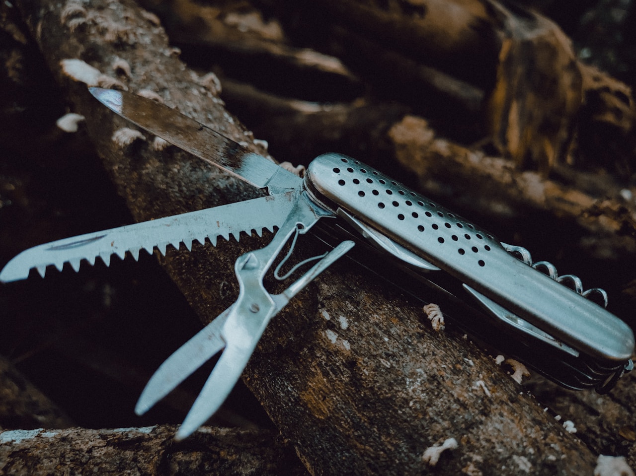 silver multi tool on brown rock